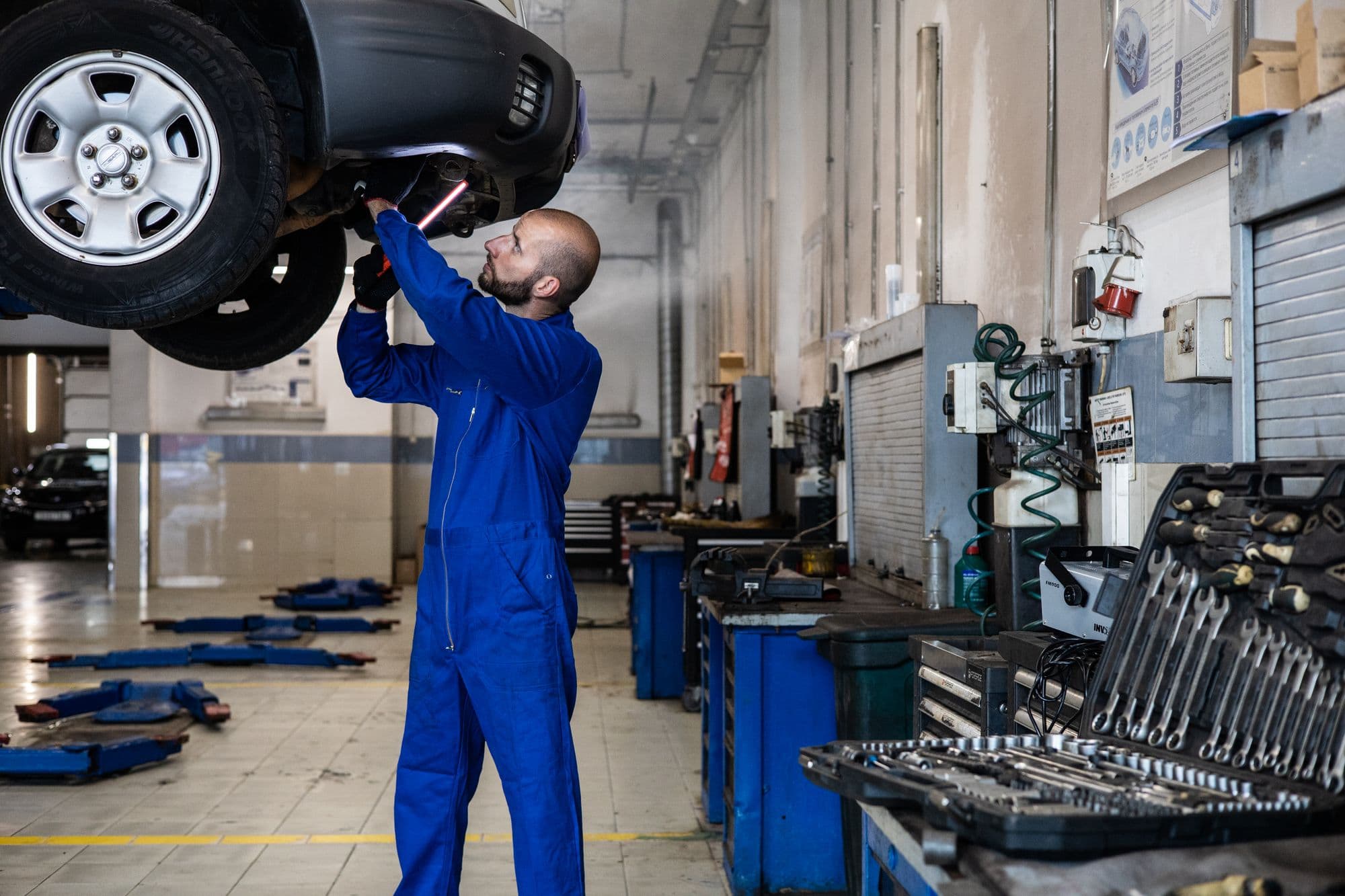A mechanic checking a white SUV in the workshop