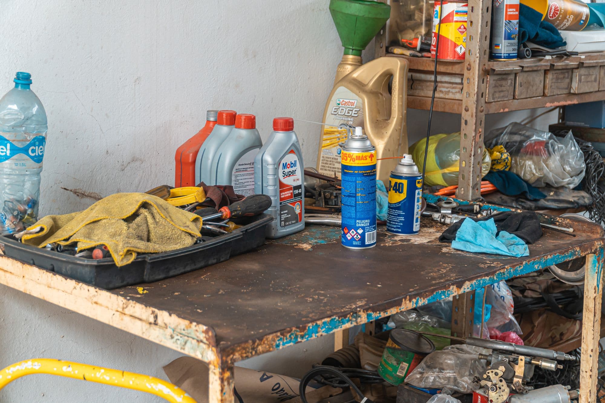 Oil containers and tools on a rusty workshop table